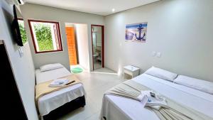 a room with two beds and a window at Pousada Angellus in Paraty +34 photos