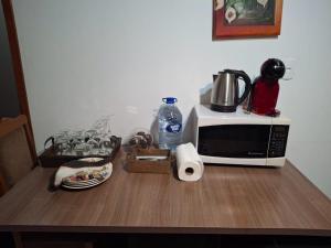 a table with a microwave and other items on it at Casa da Dôdi in São Joaquim