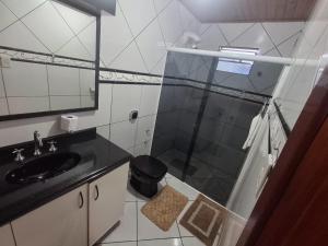 a bathroom with a shower and a sink and a mirror at Casa da Dôdi in São Joaquim