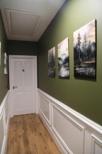 a hallway with four paintings on the wall at Ambassador House in Carrick on Shannon +32 photos