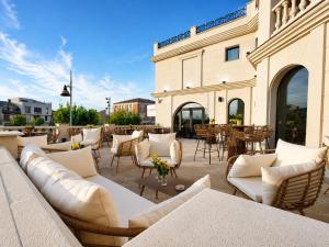 a patio with white couches and tables and a building at Zarú Hotel Boutique in Mocejón