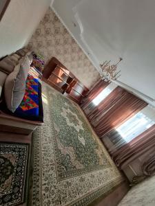 a bedroom with a bed and a window and a rug at OMKA Guest House in Toktogul