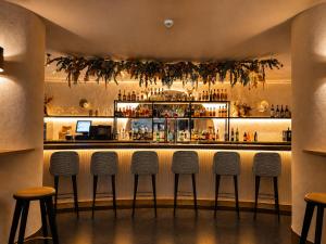 a bar with four stools in front of a counter at Zarú Hotel Boutique in Mocejón