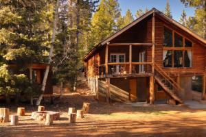 a log cabin in the woods with trees at Rustic Mountain Log Cabin with Fire Pit in Duck Creek Village