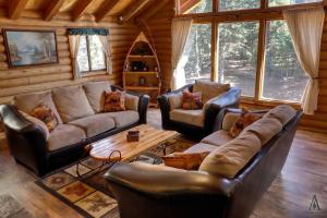 a living room with leather furniture in a log cabin at Rustic Mountain Log Cabin with Fire Pit in Duck Creek Village