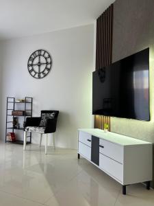 ein Wohnzimmer mit Fernseher und einem weißen Schrank in der Unterkunft LiboroView in Niš