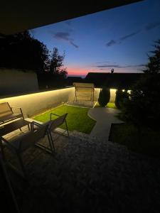 Nachtansicht eines Gartens mit zwei Stühlen auf einer Terrasse in der Unterkunft LiboroView in Niš