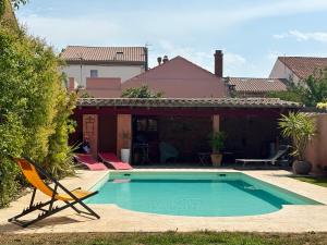 a swimming pool in a yard with a chair at La Cathare in Lézignan-Corbières