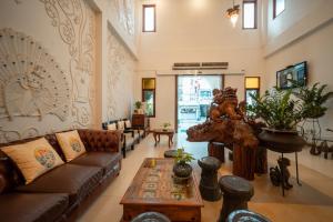a living room with a couch and a table at Kodchasri Thani Heritage Collections in Chiang Mai