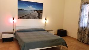a bedroom with a bed and a painting on the wall at Casa Alpamar in Villasimius