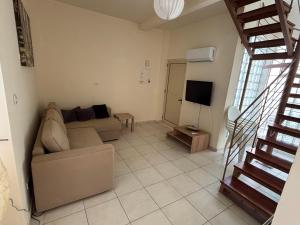 a living room with a couch and a television at Theodorou Town Residence in Strovolos
