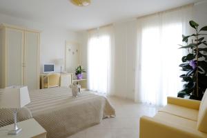 a large white room with a bed and a couch at Residence Suite Smeraldo in Riccione