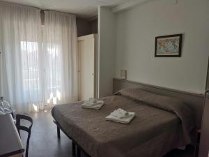 a bedroom with a bed with two towels on it at Hotel Europa in Arma di Taggia