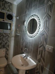 a bathroom with a sink and a mirror on the wall at عمارة 14 in Madīnat ash Shurūq +16 photos