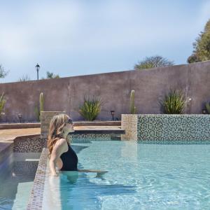a woman is sitting in a swimming pool at Parra del Valle Hotel Boutique in Valle de Guadalupe