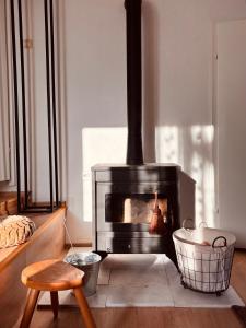 a fireplace in a living room with a chair and a stool at Bragorski Apartment in Makedonski Brod