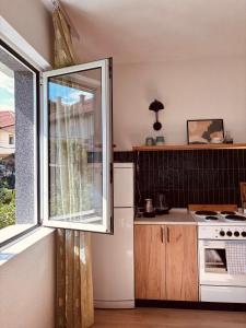 a kitchen with a window and a white refrigerator at Bragorski Apartment in Makedonski Brod +30 photos