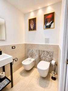 a bathroom with a white toilet and a sink at VR-Room in Forte Village