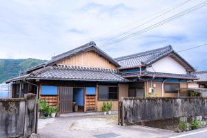 a house with a fence in front of it at 錆と煤 sabitosusu INN-prema- in Aki