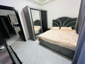 a bedroom with a bed and a large mirror at شقة أنيقة-غرفتين وصالة مع بلكونة Stylish 2-Bedroom Apartment with Balcony in Amman