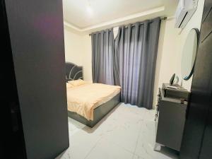 a small bedroom with a bed and a mirror at شقة أنيقة-غرفتين وصالة مع بلكونة Stylish 2-Bedroom Apartment with Balcony in Amman