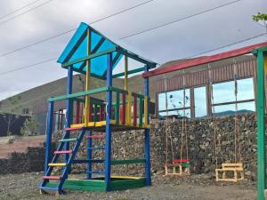 a playground with a colorful slide and swings at GlamPark in Kurmenty