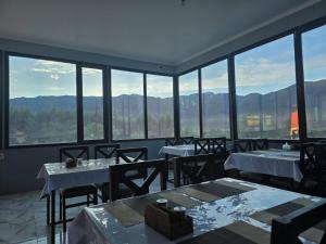 a restaurant with tables and chairs with mountains in the background at GlamPark in Kurmenty
