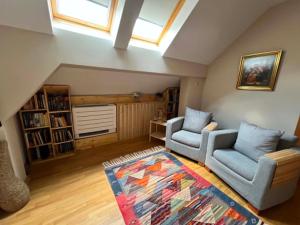 a living room with two chairs and a rug at U Izhu with Private Pool, Sauna & BBQ in Prevala