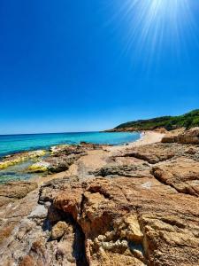 a view of a beach with rocks and the ocean at VR-Room in Forte Village +1 photo