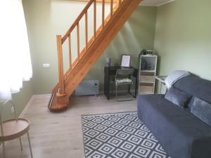 a living room with a couch and a staircase at Lerihouse in Saulkrasti