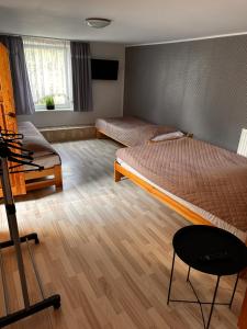 a room with two beds and a chair in it at Agroturystyka Pod Podkową in Darłowo