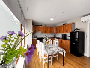 a kitchen with a table and chairs and a black refrigerator at The Ambassador Apartment in Carrick on Shannon