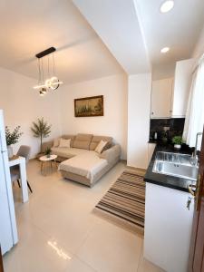 a living room with a couch and a kitchen at Drasa Harmony Apartment in Gjirokastër +19 photos