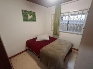 a bedroom with a bed and a window at Casa da Dôdi in São Joaquim