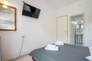a bedroom with a bed with a flat screen tv on the wall at Narkissos Hotel in Kamari +60 photos