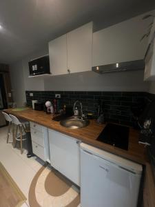 a kitchen with a sink and a counter top at Studio meublé in Orsay