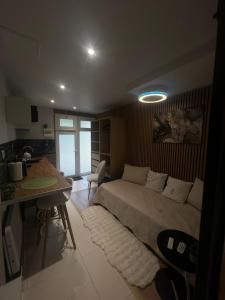 a bedroom with a bed and a table and a kitchen at Studio meublé in Orsay