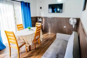 a dining room with a table and chairs and a couch at Cabañas Henua Iti in Hanga Roa