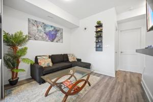 a living room with a couch and a glass table at Exquisite, Bright & Modern Condo - Free Parking in Niagara Falls