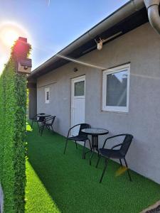a patio with tables and chairs on the grass at Fly & Stay Apartments in Laktaši