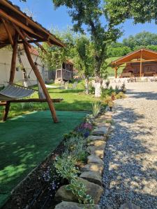 a garden with a swing and a stone path at Cazare La Cetate in Moşna