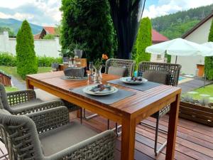 a wooden table and chairs on a wooden deck at U Izhu with Private Pool, Sauna & BBQ in Prevala
