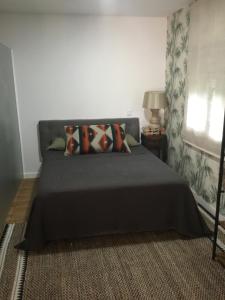 a bedroom with a bed with a black bedspread and a window at Los acebos la suite in Gallejones