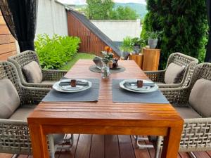 a wooden table on a patio with chairs at U Izhu with Private Pool, Sauna & BBQ in Prevala