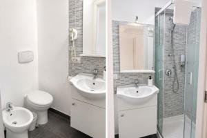 a bathroom with two sinks and a toilet and a shower at Zurria Rooms in Catania