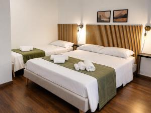 a hotel room with two beds with towels on them at Zurria Rooms in Catania