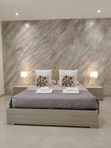 a bedroom with a large bed with two lamps at Casa Low Cost in Tuglie