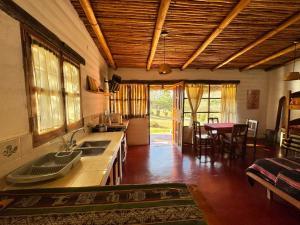 a kitchen with a sink and a table with chairs at El Caserío Jujuy in Volcán
