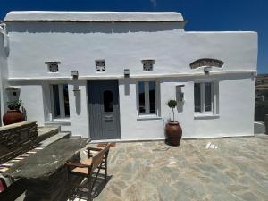 a white house with a table and chairs on a patio at Metaxana in Khatzirádhos