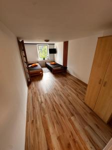 a living room with a staircase and a room with wooden floors at Agroturystyka Pod Podkową in Darłowo